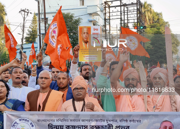 Activists of India's Hindu Jagaran Mancha, along with monks of ISKCON, hold placards showing a photo of Chinmoy Krishna Das Brahmachari, a B...