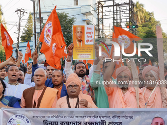 Activists of India's Hindu Jagaran Mancha, along with monks of ISKCON, hold placards showing a photo of Chinmoy Krishna Das Brahmachari, a B...