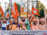 Activists of India's Hindu Jagaran Mancha, along with monks of ISKCON, hold placards showing a photo of Chinmoy Krishna Das Brahmachari, a B...