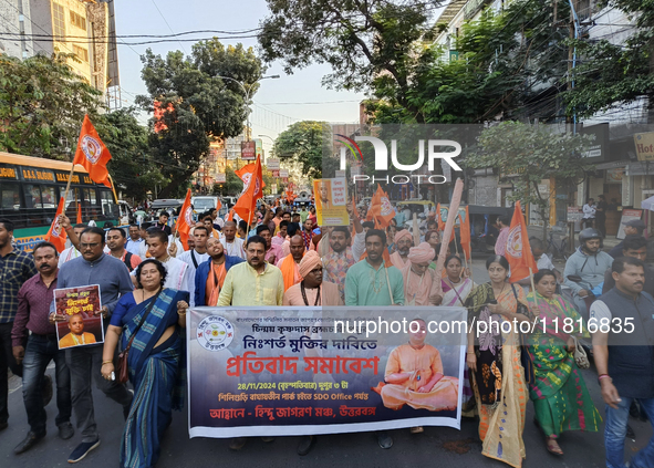 Activists of India's Hindu Jagaran Mancha, along with monks of ISKCON, hold placards showing a photo of Chinmoy Krishna Das Brahmachari, a B...