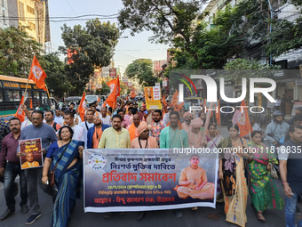 Activists of India's Hindu Jagaran Mancha, along with monks of ISKCON, hold placards showing a photo of Chinmoy Krishna Das Brahmachari, a B...