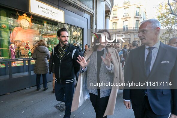 French Delegate Minister of Tourism Economy Marina Ferrari (C) observes the Christmas windows outside the Printemps department store in cent...