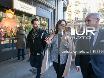 French Delegate Minister of Tourism Economy Marina Ferrari (C) observes the Christmas windows outside the Printemps department store in cent...