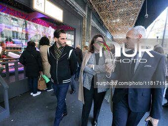 French Delegate Minister of Tourism Economy Marina Ferrari (C) observes the Christmas windows outside the Printemps department store in cent...