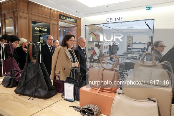 French Delegate Minister of Tourism Economy Marina Ferrari (C) observes the Christmas windows outside the Printemps department store in cent...