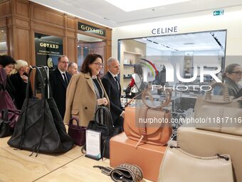 French Delegate Minister of Tourism Economy Marina Ferrari (C) observes the Christmas windows outside the Printemps department store in cent...