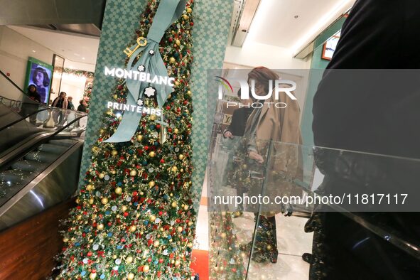 French Delegate Minister of Tourism Economy Marina Ferrari (C) observes the Christmas windows outside the Printemps department store in cent...