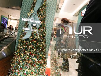 French Delegate Minister of Tourism Economy Marina Ferrari (C) observes the Christmas windows outside the Printemps department store in cent...