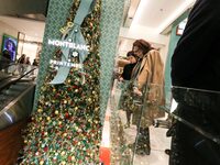 French Delegate Minister of Tourism Economy Marina Ferrari (C) observes the Christmas windows outside the Printemps department store in cent...