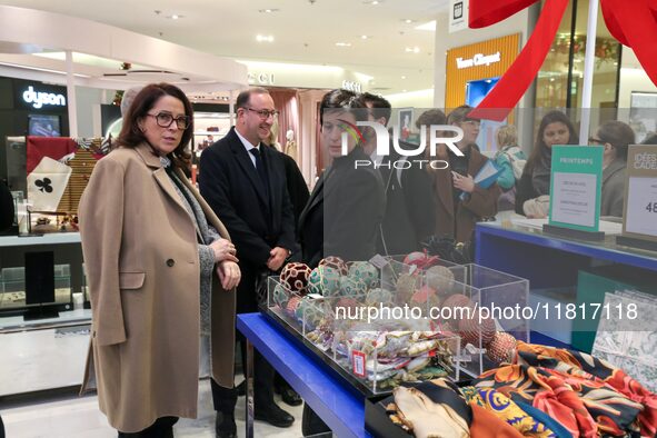 French Delegate Minister of Tourism Economy Marina Ferrari (C) observes the Christmas windows outside the Printemps department store in cent...