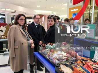 French Delegate Minister of Tourism Economy Marina Ferrari (C) observes the Christmas windows outside the Printemps department store in cent...