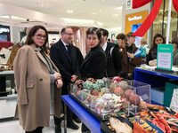 French Delegate Minister of Tourism Economy Marina Ferrari (C) observes the Christmas windows outside the Printemps department store in cent...