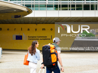 Two people walk in front of the Berlaymont building in Brussels, Belgium, on July 30, 2023. Recognized as the headquarters of the European C...