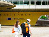 Two people walk in front of the Berlaymont building in Brussels, Belgium, on July 30, 2023. Recognized as the headquarters of the European C...