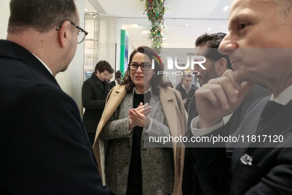 French Delegate Minister of Tourism Economy Marina Ferrari (C) observes the Christmas windows outside the Printemps department store in cent...