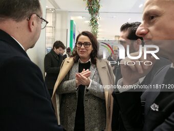 French Delegate Minister of Tourism Economy Marina Ferrari (C) observes the Christmas windows outside the Printemps department store in cent...