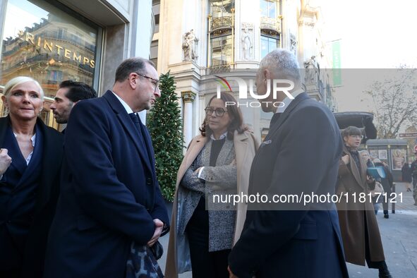 French Delegate Minister of Tourism Economy Marina Ferrari (C) observes the Christmas windows outside the Printemps department store in cent...