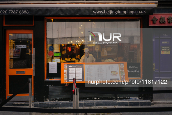 A member of staff is seen at a window of a restaurant in Chinatown, London, on November 28, 2024. 