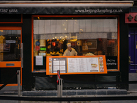 A member of staff is seen at a window of a restaurant in Chinatown, London, on November 28, 2024. (