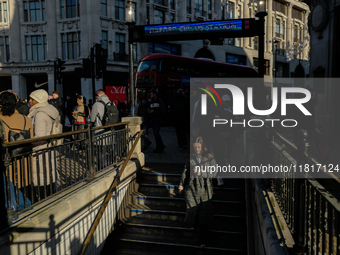 People descend into the Oxford Circus underground station in London, United Kingdom, on November 28, 2024. (