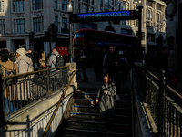 People descend into the Oxford Circus underground station in London, United Kingdom, on November 28, 2024. (