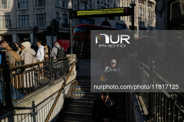 People descend into the Oxford Circus underground station in London, United Kingdom, on November 28, 2024. 