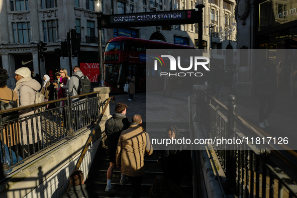 People descend into the Oxford Circus underground station in London, United Kingdom, on November 28, 2024. 