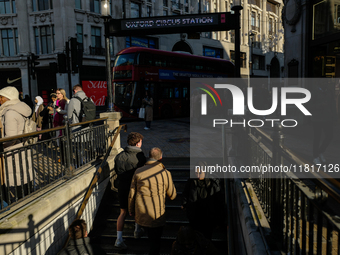 People descend into the Oxford Circus underground station in London, United Kingdom, on November 28, 2024. (