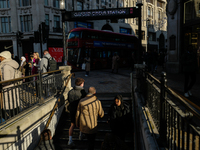 People descend into the Oxford Circus underground station in London, United Kingdom, on November 28, 2024. (