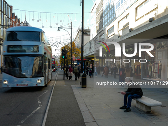 People walk on Oxford Street in London, United Kingdom, on November 28, 2024. (