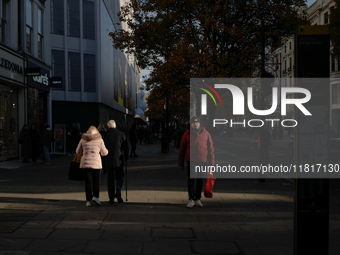 People walk on Oxford Street in London, United Kingdom, on November 28, 2024. (