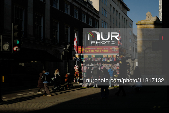 People walk past a souvenirs kiosk on Oxford Street in London, England, on November 28, 2024. 