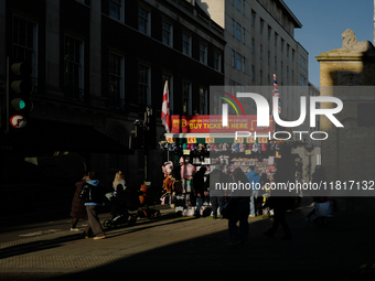 People walk past a souvenirs kiosk on Oxford Street in London, England, on November 28, 2024. (