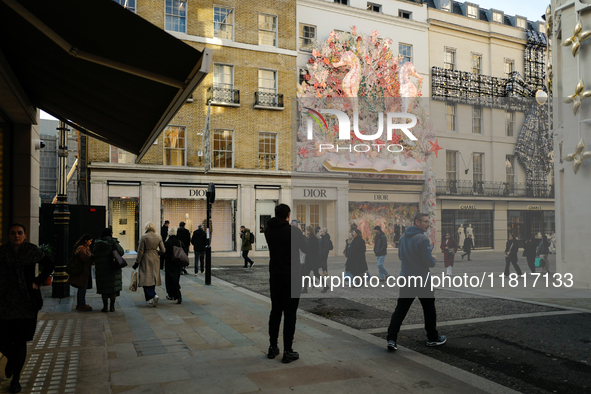 Christmas decorations are placed on the facades of shop windows in Mayfair, London, on November 28, 2024, the day before Black Friday. 