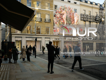 Christmas decorations are placed on the facades of shop windows in Mayfair, London, on November 28, 2024, the day before Black Friday. (