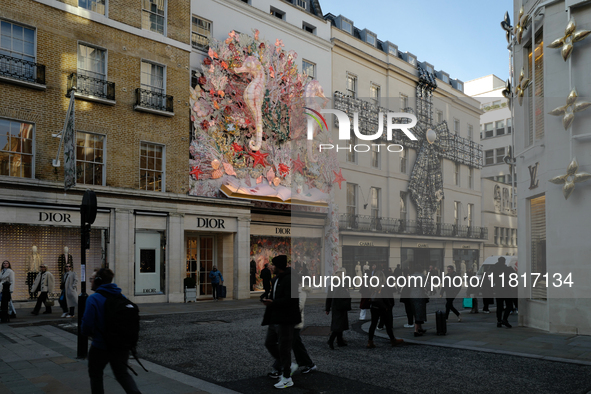 Christmas decorations are placed on the facades of shop windows in Mayfair, London, on November 28, 2024, the day before Black Friday. 