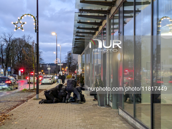 Police officers overpower a man on Bahnhofstrasse on November 28, 2024 