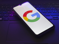 The Google logo appears on the screen of a smartphone that rests on top of a laptop keyboard in Reno, United States, on November 28, 2024. (