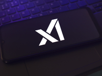 The X.AI Corp. logo appears on the screen of a smartphone that rests on top of the laptop keyboard in Reno, United States, on November 28, 2...