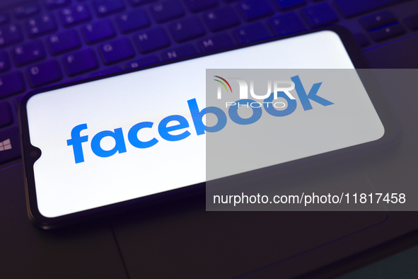 The Facebook logo appears on the screen of a smartphone that rests on top of a laptop keyboard in Reno, United States, on November 28, 2024....