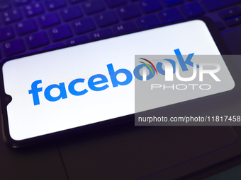 The Facebook logo appears on the screen of a smartphone that rests on top of a laptop keyboard in Reno, United States, on November 28, 2024....