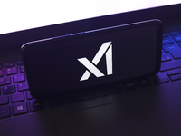 The X.AI Corp. logo appears on the screen of a smartphone that rests on top of the laptop keyboard in Reno, United States, on November 28, 2...