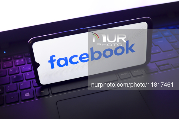 The Facebook logo appears on the screen of a smartphone that rests on top of a laptop keyboard in Reno, United States, on November 28, 2024....