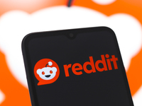 The Reddit logo appears on the screen of a smartphone and in the background on the computer screen in Reno, United States, on November 28, 2...