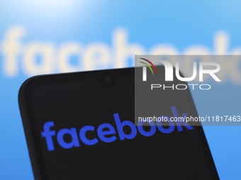 The Facebook logo appears on the screen of a smartphone and in the background on the computer screen in Reno, United States, on November 28,...