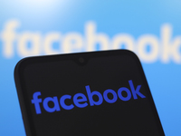 The Facebook logo appears on the screen of a smartphone and in the background on the computer screen in Reno, United States, on November 28,...