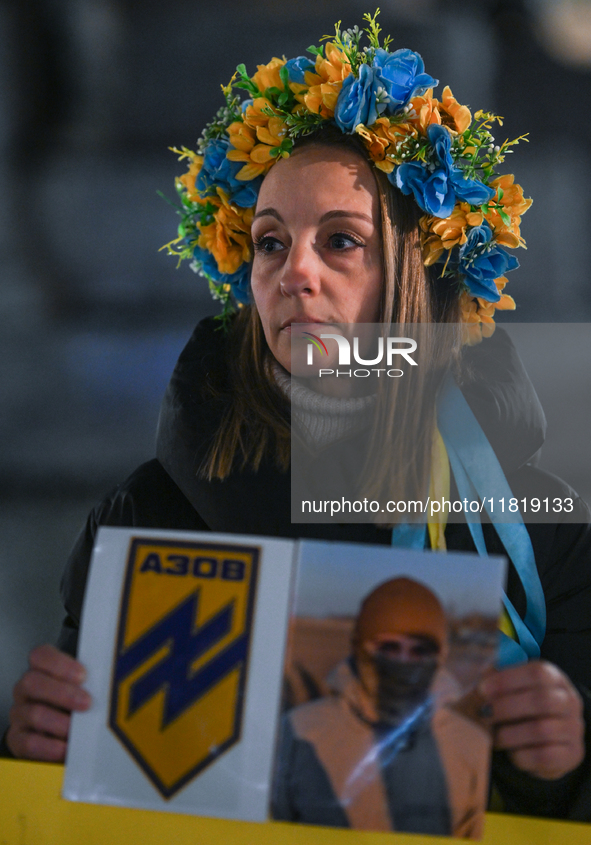 KRAKOW, POLAND - NOVEMBER 28:
A protester wearing a wreath in Ukrainian colors on the evening of the 1009th day of Russia's invasion of Ukra...