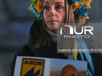 KRAKOW, POLAND - NOVEMBER 28:
A protester wearing a wreath in Ukrainian colors on the evening of the 1009th day of Russia's invasion of Ukra...