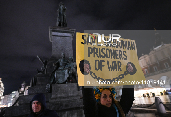 KRAKOW, POLAND - NOVEMBER 28:
A protester wearing a wreath in Ukrainian colors holds a poster reading 'Save Ukrainian Prisoniers of War' on...