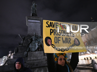 KRAKOW, POLAND - NOVEMBER 28:
A protester wearing a wreath in Ukrainian colors holds a poster reading 'Save Ukrainian Prisoniers of War' on...